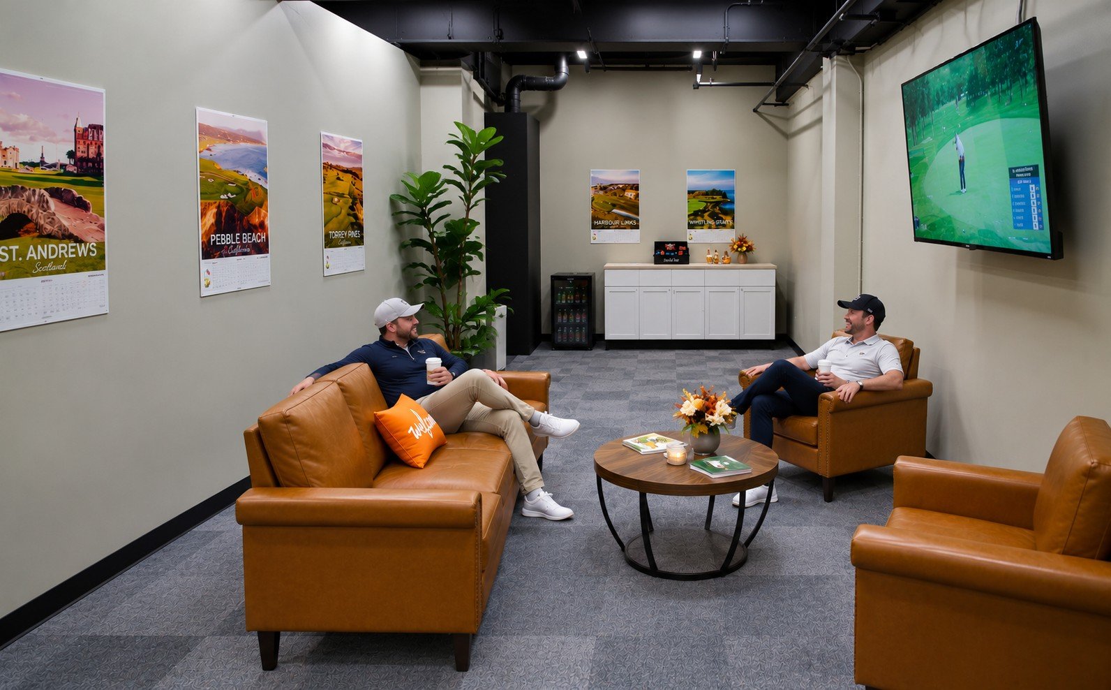 Golfers relaxing in the APEX Golf Lab member lounge with leather seating