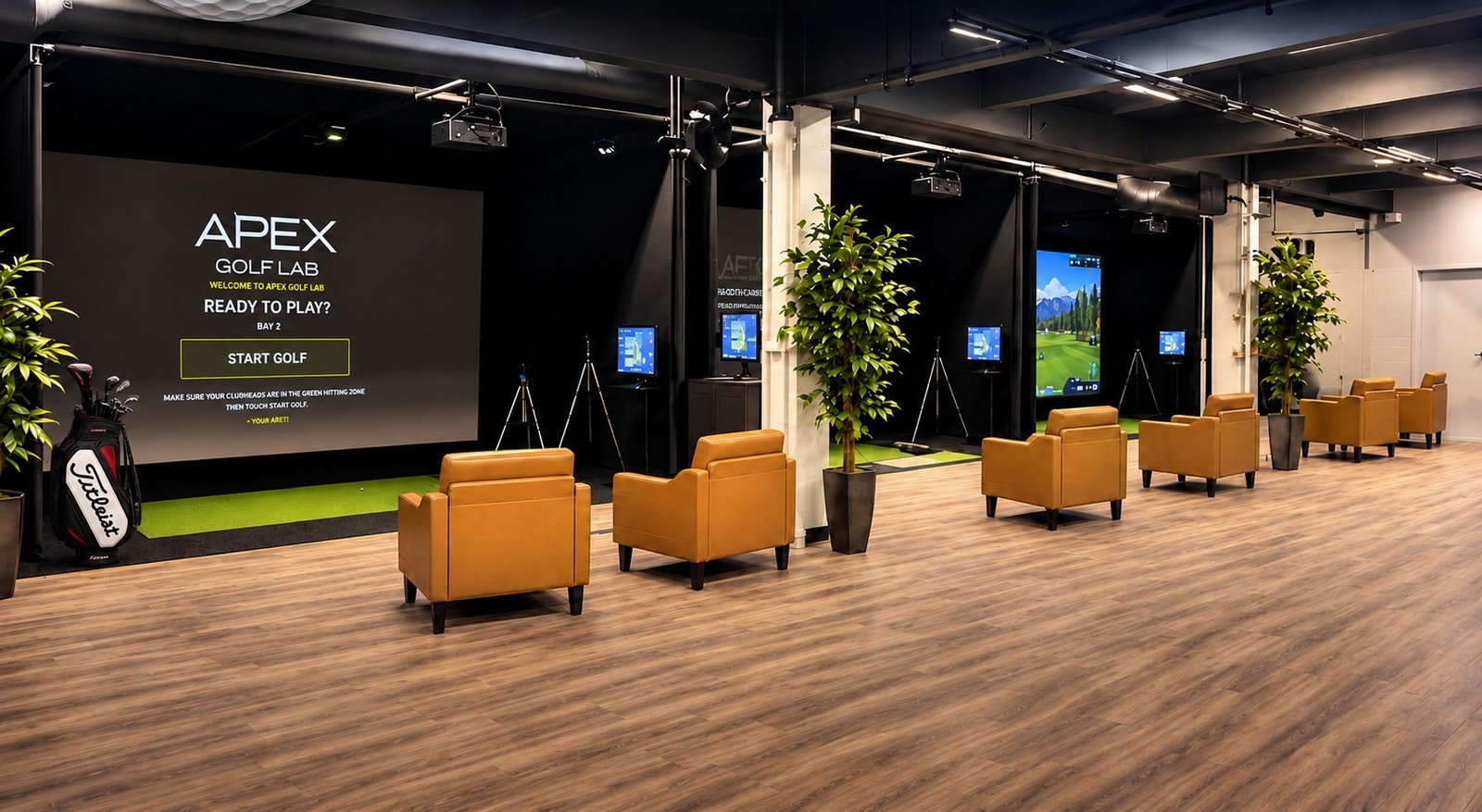 Four modern indoor golf simulator bays at APEX Golf Lab with comfortable seating